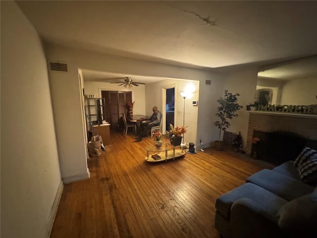 206 Thoroughman Ave, Ferguson, MO 63135 - living area featuring wood-type flooring, baseboards, ceiling fan, and a brick fireplace