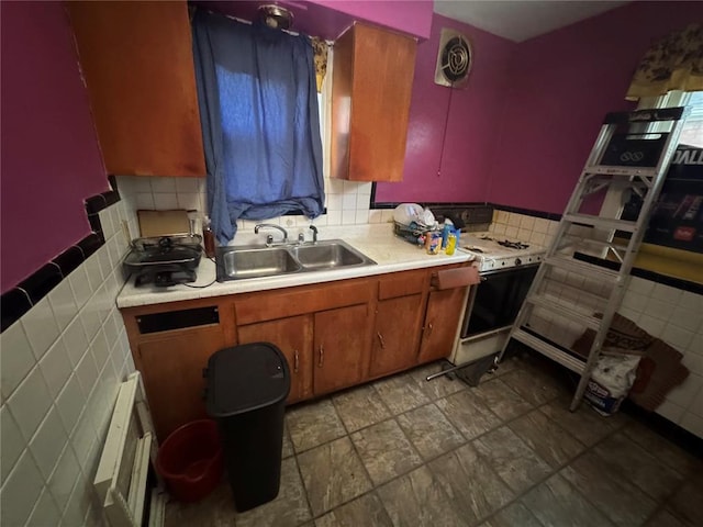 206 Thoroughman Ave, Ferguson, MO 63135 - kitchen with a sink, tile walls, light countertops, white gas range, and brown cabinets