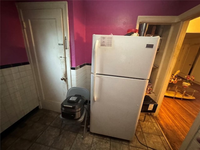 206 Thoroughman Ave, Ferguson, MO 63135 - kitchen featuring freestanding refrigerator, a wainscoted wall, and tile walls