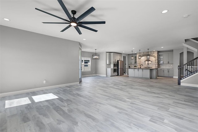535 Crail Ct, Ofallon, MO 63368 - unfurnished living room featuring recessed lighting, stairs, light wood-style floors, baseboards, and ceiling fan