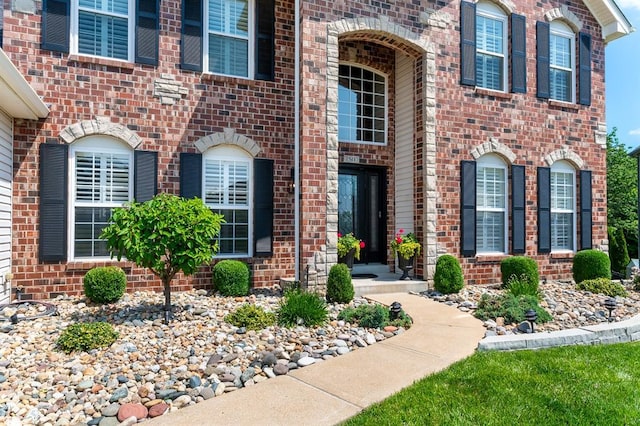 entrance to property featuring brick siding