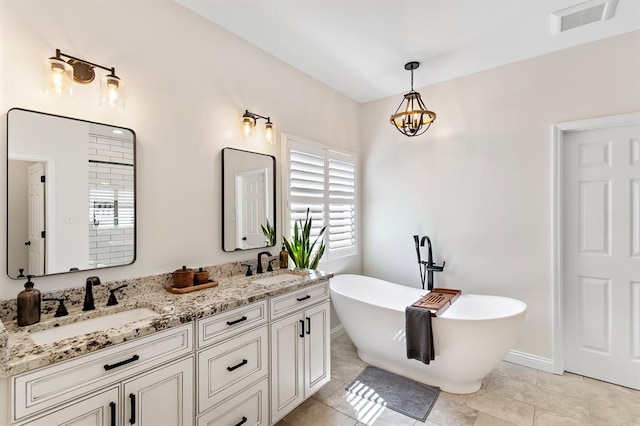 bathroom with a soaking tub, double vanity, tile patterned floors, and baseboards