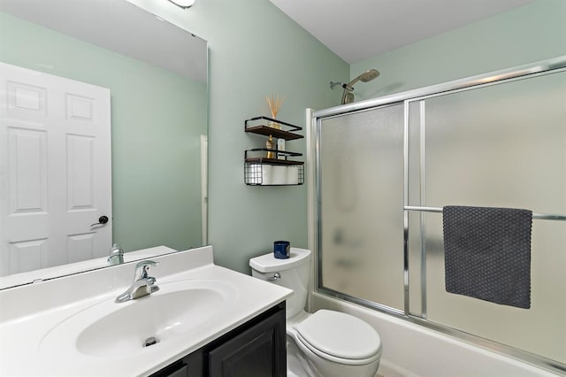 full bathroom with vanity, bath / shower combo with glass door, and toilet