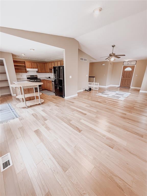 222 Elm Dr, Fairview Heights, IL 62208 - unfurnished living room featuring baseboards, light wood-style floors, a ceiling fan, and vaulted ceiling