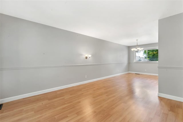 1137 Great Falls Ct, Manchester, MO 63021 - spare room with a chandelier, light wood-type flooring, and baseboards