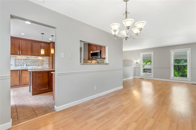 1137 Great Falls Ct, Manchester, MO 63021 - unfurnished living room featuring a chandelier, light wood-style floors, baseboards, and recessed lighting