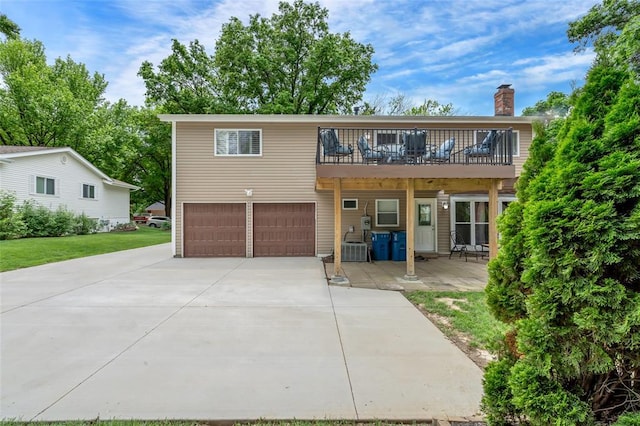 1137 Great Falls Ct, Manchester, MO 63021 - view of front of home featuring an attached garage, a chimney, concrete driveway, and a balcony
