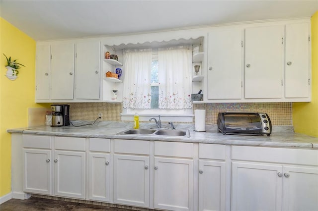 kitchen with open shelves, a sink, tasteful backsplash, and white cabinetry