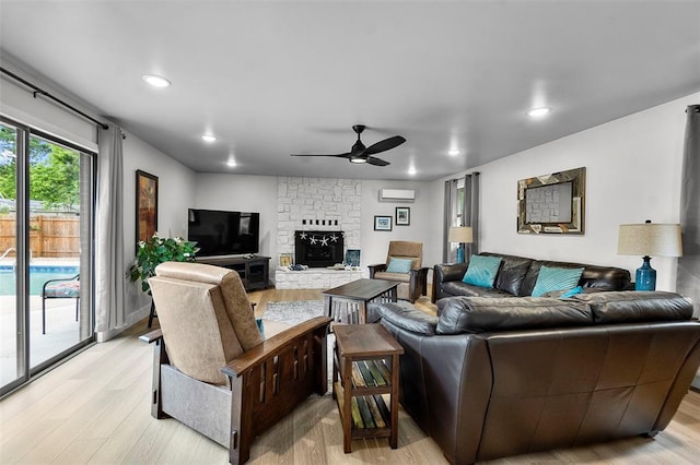 1719 Oak Hills St, Cape Girardeau, MO 63701 - living room with light wood-style floors, ceiling fan, a wall mounted air conditioner, a stone fireplace, and recessed lighting