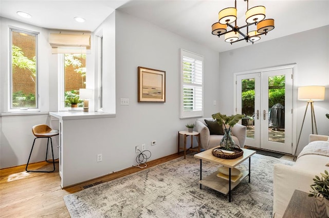living room with a chandelier, light wood-type flooring, french doors, and recessed lighting