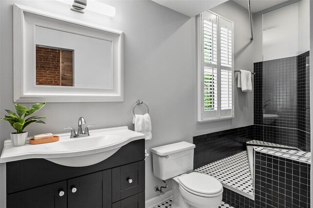 full bath with toilet, a walk in shower, vanity, baseboards, and tile patterned floors