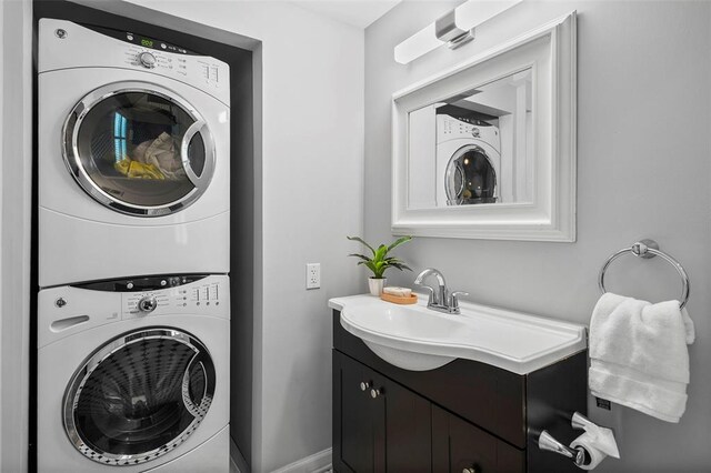bathroom featuring stacked washer and clothes dryer and vanity