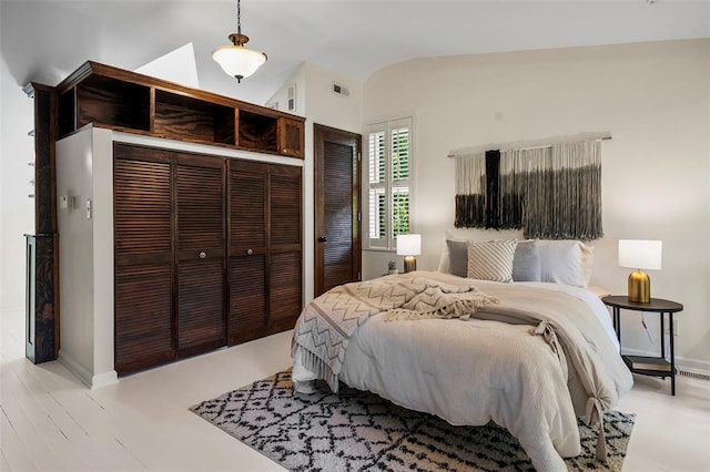 bedroom with lofted ceiling, a closet, and baseboards
