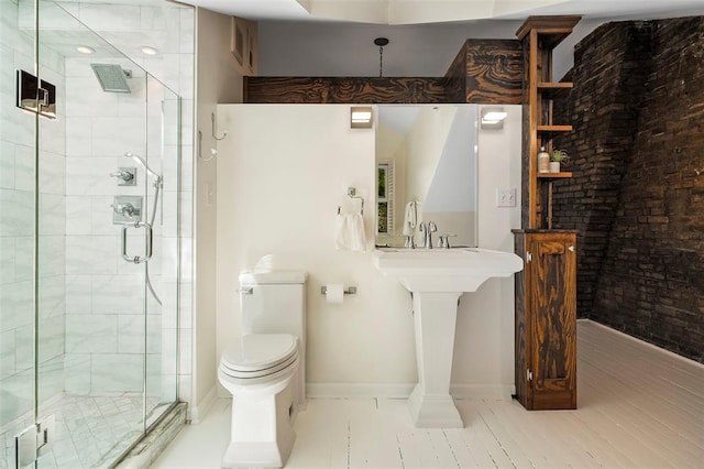 full bathroom featuring a stall shower, baseboards, and toilet
