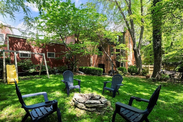 view of grassy yard featuring an outdoor fire pit