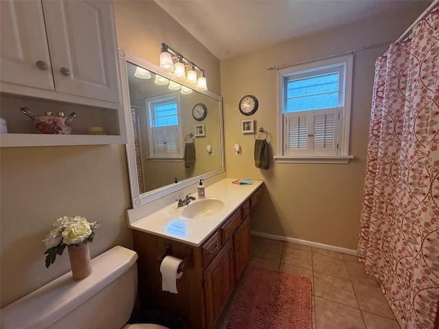 bathroom featuring tile patterned flooring, vanity, baseboards, and toilet