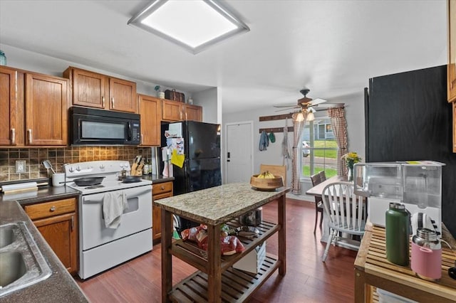 15 W 13th St, Washington, MO 63090 - kitchen with black appliances, dark wood-style floors, tasteful backsplash, and brown cabinets