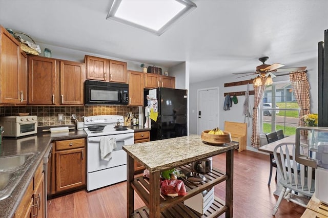 15 W 13th St, Washington, MO 63090 - kitchen featuring black appliances, brown cabinets, backsplash, and light wood finished floors