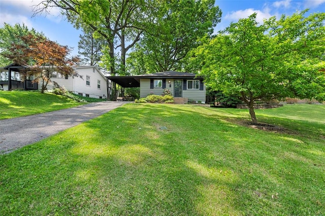 view of front of property with asphalt driveway, a carport, and a front lawn