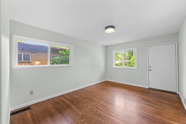 spare room featuring wood finished floors and baseboards