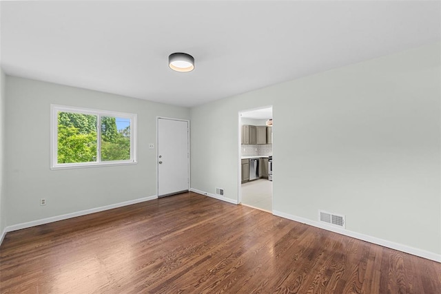 empty room with baseboards and wood finished floors