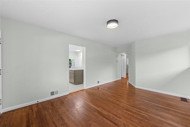 empty room featuring wood finished floors and baseboards