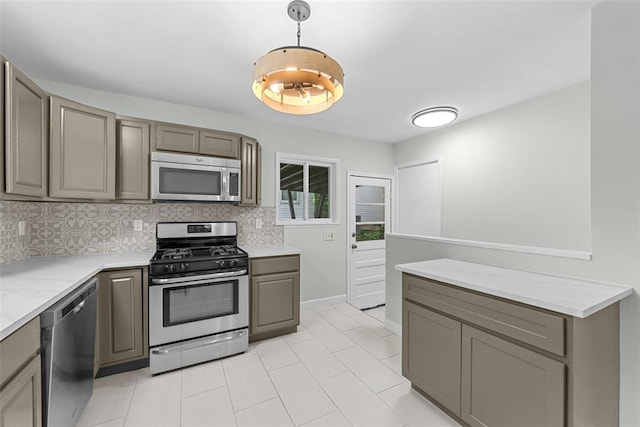 kitchen with stainless steel appliances, gray cabinetry, decorative backsplash, and decorative light fixtures