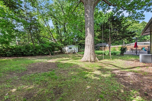 view of yard with central AC unit and an outbuilding