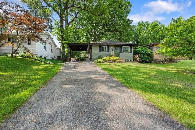 view of front facade with asphalt driveway, a front yard, and an attached carport