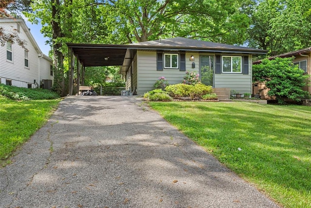 view of front of home featuring driveway, central air condition unit, a front lawn, and a carport