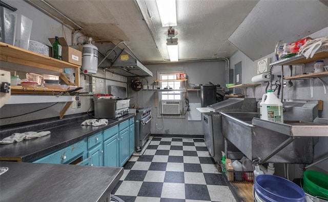 108 College Ave, Licking, MO 65542 - kitchen featuring dark floors, blue cabinetry, open shelves, ventilation hood, and dark countertops