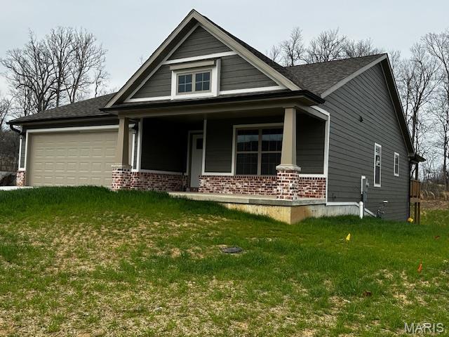 289 Broch Tuarach Pl, Jackson, MO 63755 - view of front of home featuring a porch, brick siding, an attached garage, and a front lawn