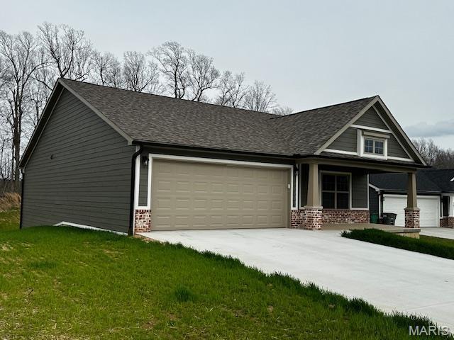 289 Broch Tuarach Pl, Jackson, MO 63755 - view of front facade with a garage, brick siding, concrete driveway, a front yard, and roof with shingles