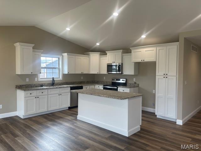 289 Broch Tuarach Pl, Jackson, MO 63755 - kitchen with stainless steel appliances, white cabinetry, a sink, vaulted ceiling, and a center island