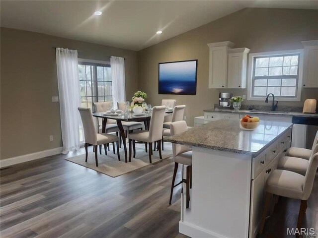 289 Broch Tuarach Pl, Jackson, MO 63755 - kitchen with a kitchen bar, vaulted ceiling, white cabinets, a sink, and dark wood finished floors