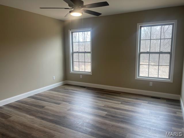 289 Broch Tuarach Pl, Jackson, MO 63755 - unfurnished room with ceiling fan, baseboards, and dark wood-style floors