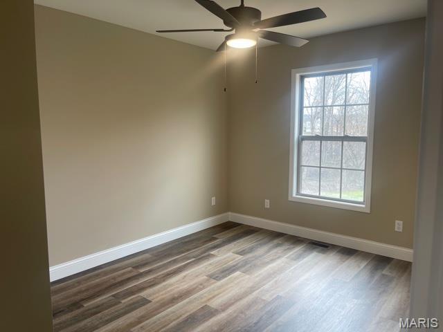 289 Broch Tuarach Pl, Jackson, MO 63755 - spare room with dark wood-style floors, baseboards, and ceiling fan