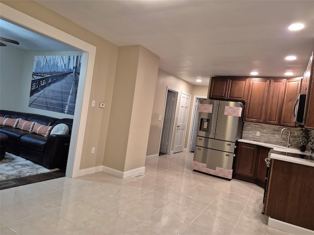 9643 Holtwood Rd, Overland, MO 63114 - kitchen featuring appliances with stainless steel finishes, light countertops, recessed lighting, baseboards, and backsplash