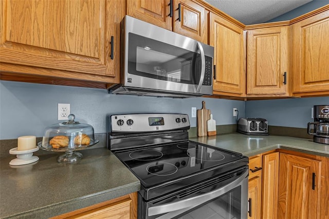 1711 El Rio Dr, Cape Girardeau, MO 63701 - kitchen featuring stainless steel appliances, dark countertops, and brown cabinets
