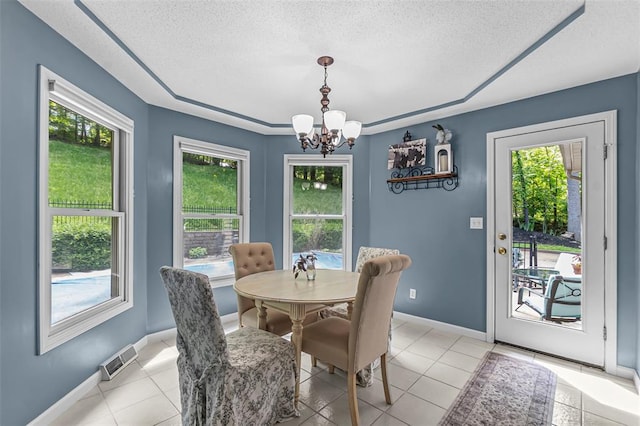 1711 El Rio Dr, Cape Girardeau, MO 63701 - dining space with a chandelier, healthy amount of natural light, a textured ceiling, and baseboards