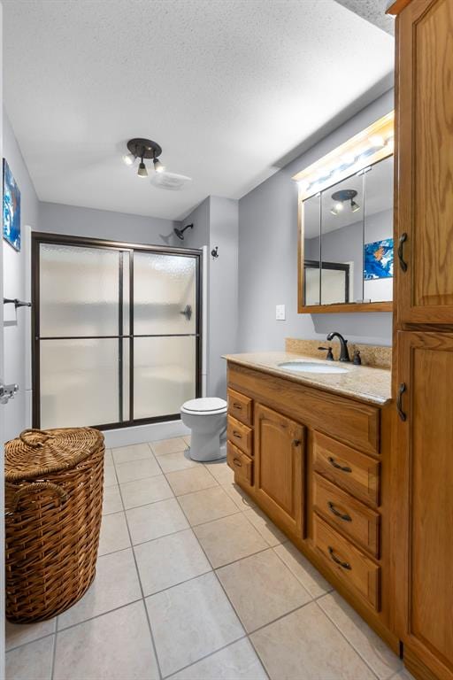 1711 El Rio Dr, Cape Girardeau, MO 63701 - bathroom with a shower with door, toilet, vanity, and tile patterned flooring