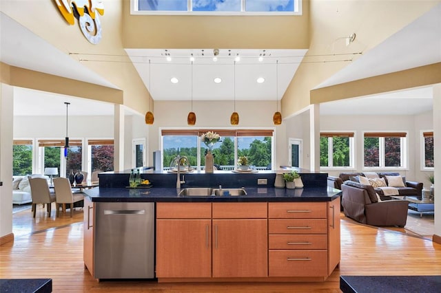 169 Fick Farm Rd, Chesterfield, MO 63005 - kitchen featuring stainless steel dishwasher, a high ceiling, a sink, open floor plan, and light wood-style flooring