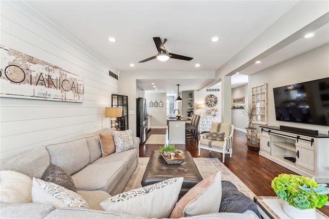 living area with a ceiling fan, dark wood-type flooring, recessed lighting, wood walls, and baseboards