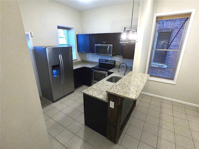 3606 Iowa Ave, Saint Louis, MO 63118 - kitchen with appliances with stainless steel finishes, a sink, a peninsula, and light tile patterned floors
