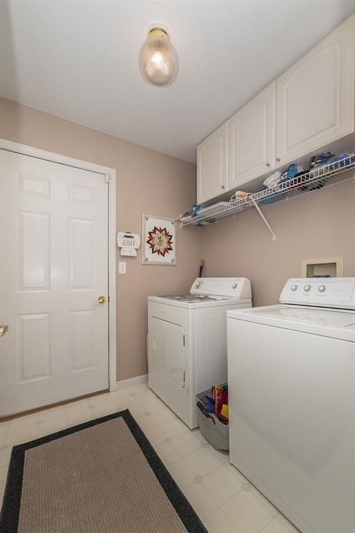 55 Rue De Paix Dr, Lake St Louis, MO 63367 - laundry room with cabinet space, washing machine and dryer, baseboards, and light floors
