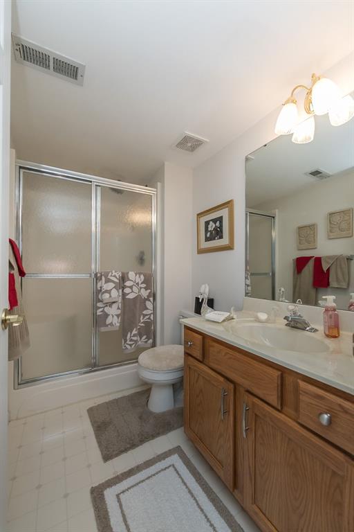 55 Rue De Paix Dr, Lake St Louis, MO 63367 - bathroom featuring vanity, toilet, and a shower stall