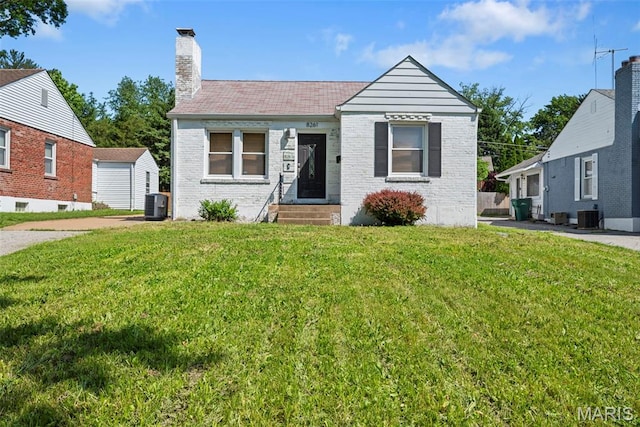 8261 Watson Rd, Saint Louis, MO 63119 - view of front of house with entry steps, a chimney, a front lawn, and brick siding
