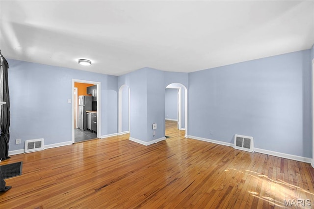 8261 Watson Rd, Saint Louis, MO 63119 - spare room featuring arched walkways and wood-type flooring