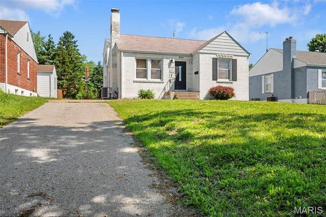 8261 Watson Rd, Saint Louis, MO 63119 - bungalow-style home with driveway, a front lawn, brick siding, and a chimney