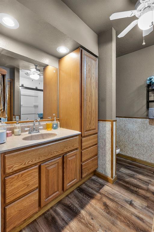 24864 Bcr 326, Marble Hill, MO 63764 - bathroom featuring wood finished floors, vanity, ceiling fan, baseboards, and toilet